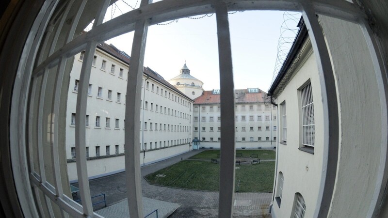 Blick durch ein Gitterfenster in einen Hof der Justizvollzugsanstalt.