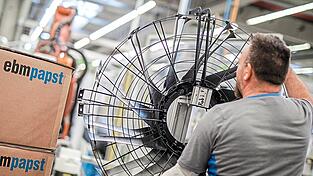Ein Mitarbeiter des Elektromotoren- und Ventilatorenherstellers Ebm-Papst arbeitet in der Produktion an einem Ventilator.