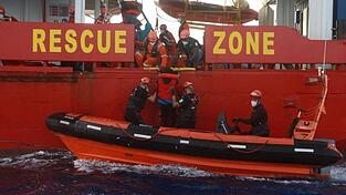 Seenotretter helfen einem Flüchtling auf das Seenotrettungsschiffs 'Sea-Eye 4'.