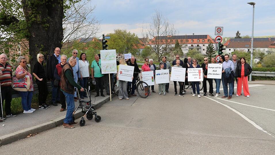 Mit Protestschildern versammelten sich etwa 30 B&uuml;rger vor der umstrittenen Rampe zur Dechbettener Br&uuml;cke.
