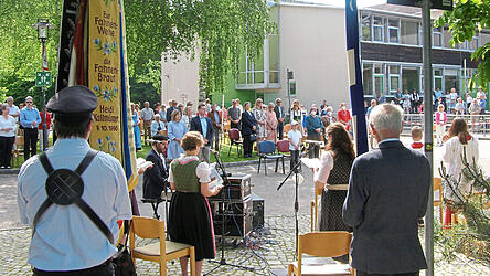 Blick zwischen den Fahnenabordnungen und die Schola mit Kirchenmusiker Élio Carneiro auf die versammelten Gläubigen, in erster Reihe Bürgermeister Helmut Fichtner mit Gattin.