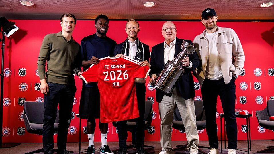 J.J. Peterka (Boston Bruins; v.l.), Alphonso Davies (FC Bayern), Rouven Kasper (Vorstand Marketing und Vertrieb FC Bayern), Bill Daly (Deputy Commissioner NHL, mit einer Nachbildung des Stanley Cups) und Leon Draisaitl (Edmonton Oilers) an der S&auml;bener Stra&szlig;e.