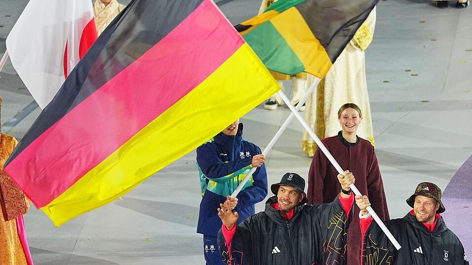 Tobias Wendl (l) und Tobias Arlt tragen die deutsche Fahne.