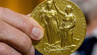 Die Rückseite der Nobel-Medaille für Physik stellt die Natur in Form einer Göttin dar, die aus den Wolken auftaucht und ein Füllhorn hält. (Illustration) Die Rückseite der Nobel-Medaille für Physik stellt die Natur in Form einer Göttin dar, die aus den Wolken auftaucht und ein Füllhorn hält. (Illustration)