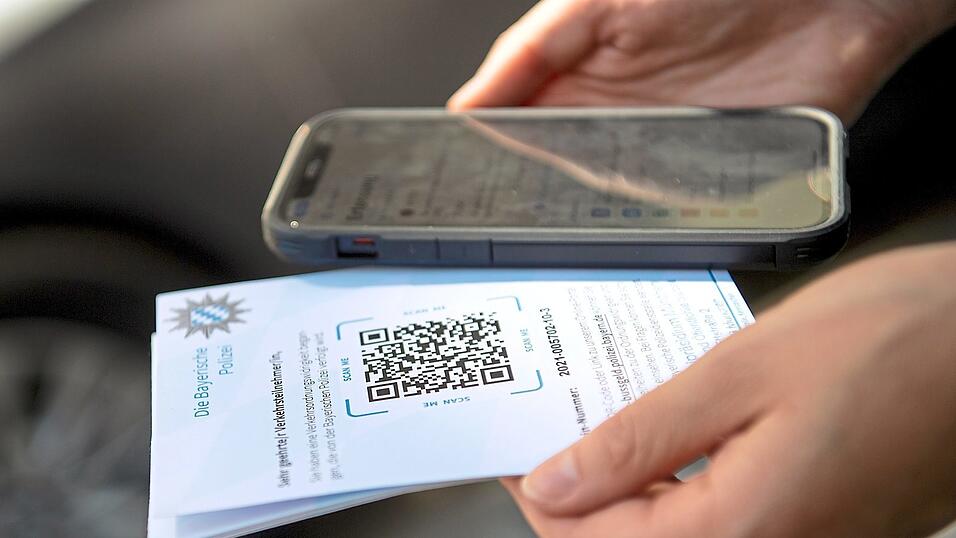 Eine Polizistin stellt einen digitalen Strafzettel aus.