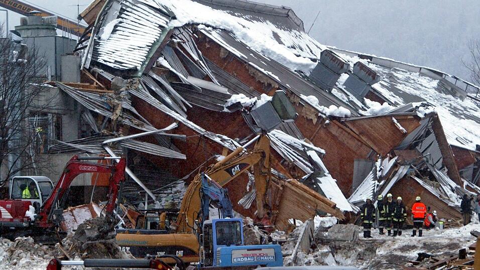 Mit Baggern trugen die Rettungskr&auml;fte die Tr&uuml;mmer der eingest&uuml;rzten Eishalle in Bad Reichenhall ab. (Archivbild)
