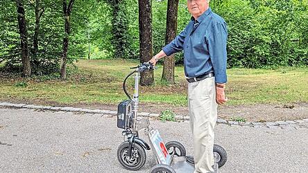 Mit E-Rollstuhl-Motor heizt Karl Paul auf seiner elektrisch betriebenen Gehhilfe durch die Stadt.