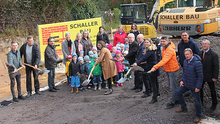 Gespannt verfolgen die Kinder und Mitarbeiter des Kindergartens Sankt Andreas den Spatenstich durch die Vertreter der Stadt, des BRK, der Baufirma und des Architekturbüros.