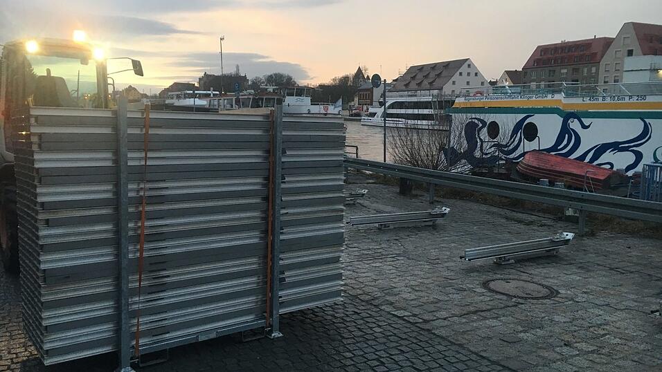 Bei Sonnenaufgang errichten st&auml;dtische Mitarbeiter in der Werftstra&szlig;e den Hochwasserschutz.