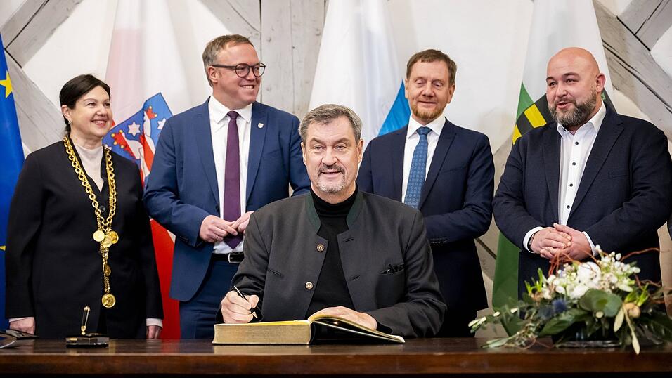 Markus Söder, umrahmt von Mario Voigt (2. v. l.) und Michael Kretschmer (2. v. r.), beim Eintrag ins Goldene Buch der Stadt Kronach