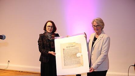Gertrud Maltz-Schwarzfischer &uuml;bergab Ilse Danzinger ein Faksimile - eine originalgetreue Nachbildung - der Gr&uuml;ndungsurkunde der Synagoge von 1912.