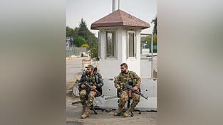 Syrische Kämpfer bewachen den Eingang eines zivilen Flughafens von Lakatia in Syrien. Die Miliz HTS, die Machthaber Assad in einer Blitzoffensive stürzte, gibt sich moderat und zugänglich.
