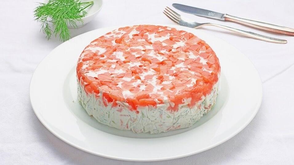 Willkommen auf unserer kulinarischen Reise! Das ist eine frische Lachs-Terrine. Die wesentlichen Zutaten sind Räucherlachs, Gurke, Sauerrahm, Zwiebeln und viel Dill. Schnell geht es auch, denn die Zubereitungszeit ist nur eine halbe Stunde. Aber dann muss die Lachstorte über Nacht im Kühlschrank fest werden.