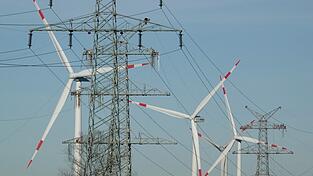 Windkraftanlagen und Strommasten - beides steht f&uuml;r den Ausbau erneuerbare Energie. (Symbolbild)