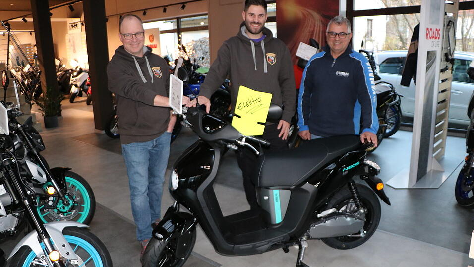 Ein Yamaha-Elektroroller ist heuer der 2. Preis. G&uuml;nther Voit von Zweirad Voit (rechts) stellt diesen Martin Eisenmann und Michael Utz (v.l.) vom Fischereiverein vor.