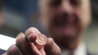 US-Schatzmeister Brandon Beach hält einen der letzten in der US-Münzanstalt in Philadelphia gepressten Pennys in die Kamera. US-Schatzmeister Brandon Beach hält einen der letzten in der US-Münzanstalt in Philadelphia gepressten Pennys in die Kamera.