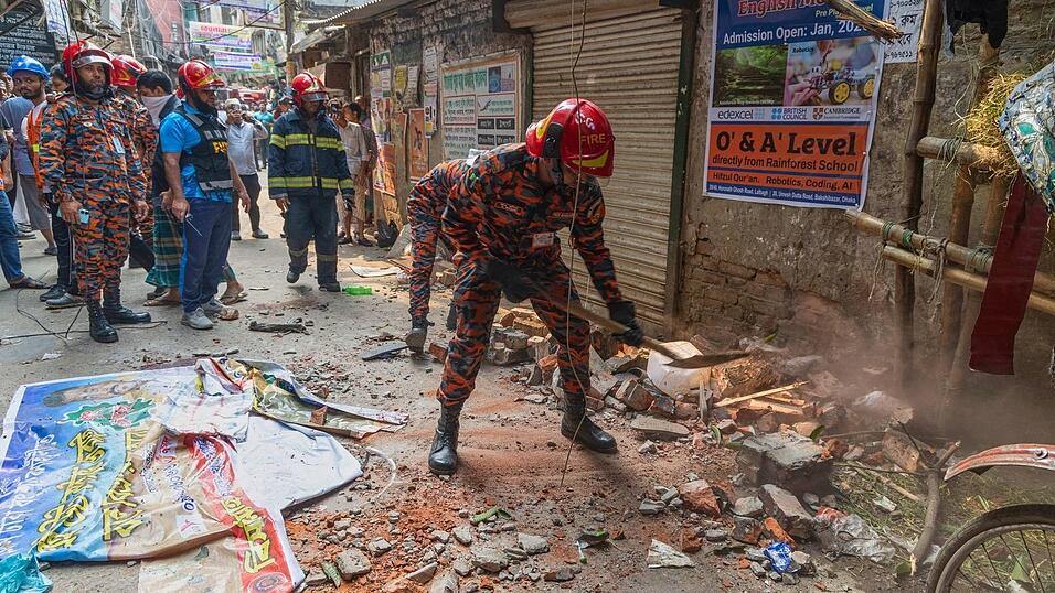Ein Rettungsdienst-Mitarbeiter räumt nach einem Erdbeben die Trümmer von eingestürzten Gebäudeteilen weg.