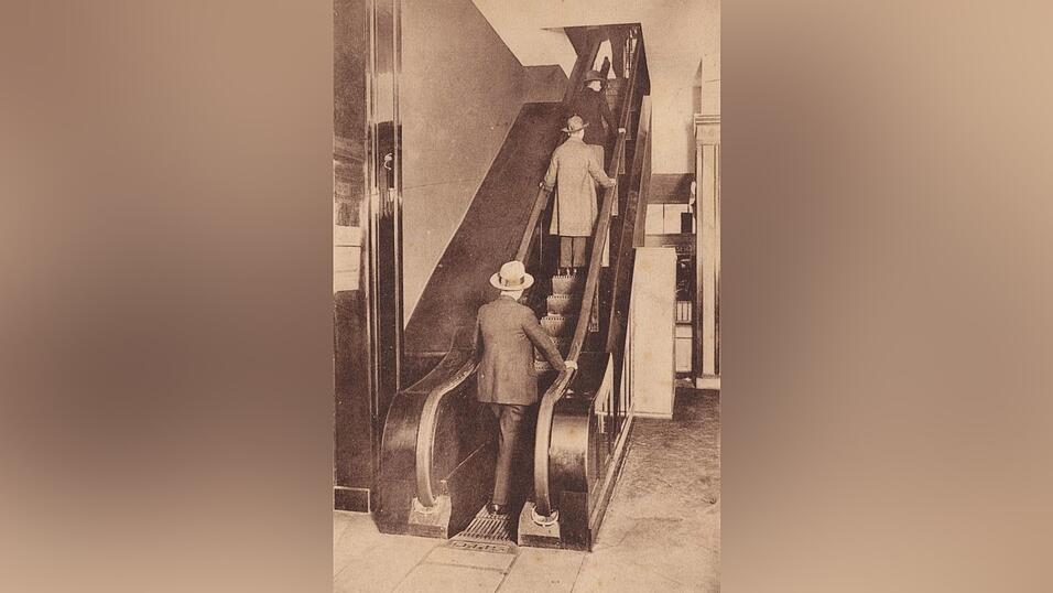 Eine Postkarte aus dem Kölnischen Stadtmuseum zeigt die erste deutsche Rolltreppe im Kölner Kaufhaus Tietz im Jahr 1925.