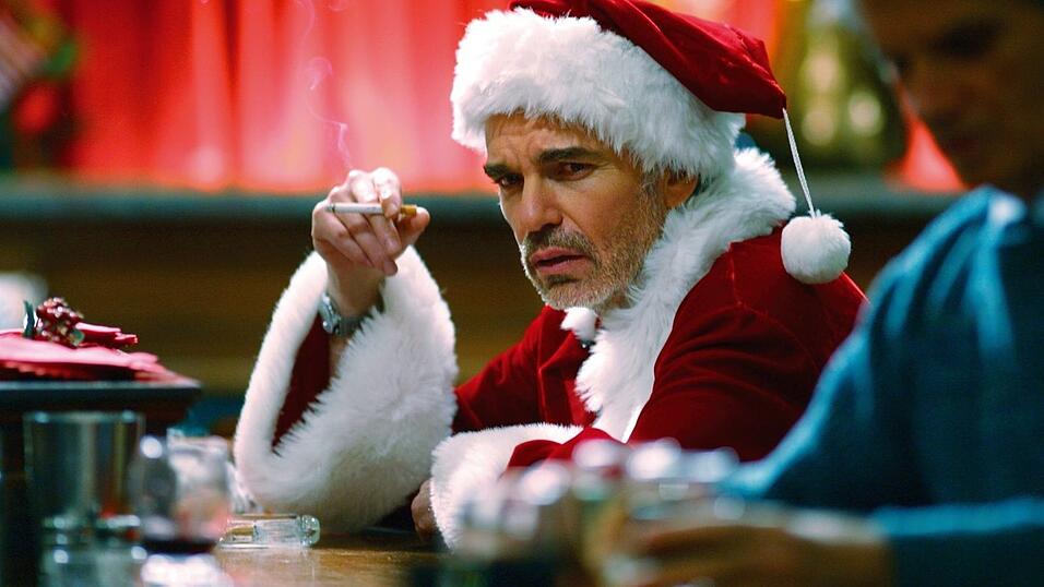 Willi (gespielt von Billy Bob Thornton) sitzt am Ende seines Arbeitstages frustriert an einer Bar (Szenenfoto). Eigentlich ist Willi ein Ekelpaket, das Kinder anp&ouml;belt und anz&uuml;gliche Witze &uuml;ber Frauen erz&auml;hlt. Doch jedes Jahr zu Weihnachten schl&uuml;pft er in die Rolle des Kaufhaus-Weihnachtsmannes. Diesen Job nutzt Willi schamlos f&uuml;r seine kriminellen Machenschaften aus. Ein sch&ouml;n schmieriger Thornton sowie das Drehbuch der Coen-Br&uuml;der ergeben eine respektlose Weihnachtskom&ouml;die.