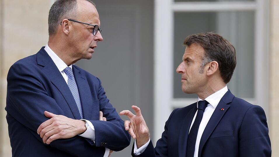 Bundeskanzler Friedrich Merz (l.) h&ouml;rt dem franz&ouml;sischen Pr&auml;sidenten Emmanuel Macron im Garten des Elysee-Palastes in Paris zu.