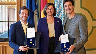 Landtagspr&auml;sidentin Ilse Aigner (CSU) zeichnet Tobias Krell und Florian David Fitz bei einem Nachholtermin mit dem Bayerischen Verfassungsorden aus.