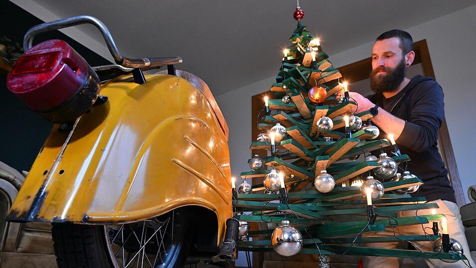 Jan Hofmann schmückt einen Weihnachtsbaum auch mit Weihnachtsbaumkugeln aus Simson-Blinkern.