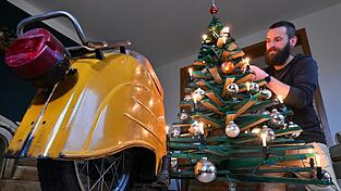 Jan Hofmann schmückt einen Weihnachtsbaum auch mit Weihnachtsbaumkugeln aus Simson-Blinkern.