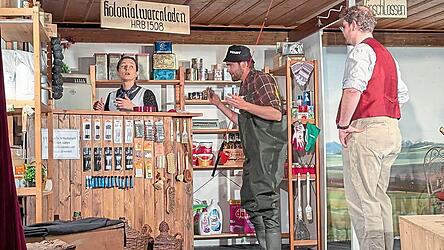 Der Kramerladen der Bimberlbergerin (Elisabeth Dendl, l.): Der Fischer &bdquo;B&uuml;ckling&ldquo; (Korbinian Ostermaier, Mitte) und der &bdquo;Knollinger&ldquo; (Bernhard Meier, r.) versuchen das zu bekommen, was sie brauchen.