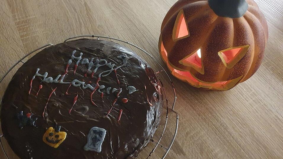 Unter der dunklen Kuvertüre verbirgt sich ein Kürbiskuchen. Der ausgehöhlte Kürbis kann zudem gleich als schaurig-schöne Deko verwendet werden.