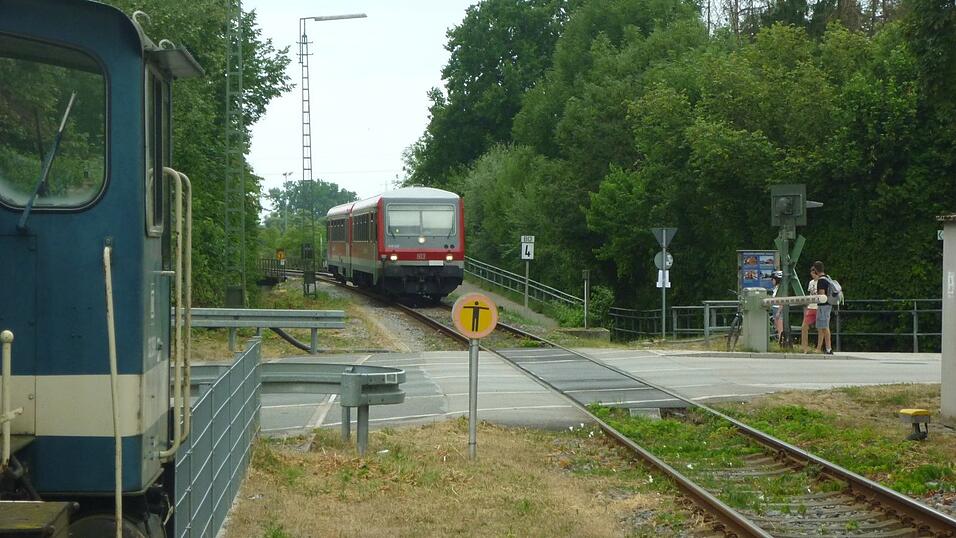 Die G&auml;ubodenbahn bei ihrer Einfahrt in Bogen, aufgenommen im Sommer 2025: Gerade hat sie die Br&uuml;cke &uuml;ber die Staatsstra&szlig;e befahren - erkennbar am Gel&auml;nder links hinter dem Zug -, sogleich wird sie die Schrankenanlage der Bahnhofstra&szlig;e (Kreisstra&szlig;e SR 3) passieren und dann an ihrer Endstation im Bahnhof Bogen halten. Auch die Staatsstra&szlig;enbr&uuml;cke muss neu errichtet werden, wenn es zum Ersatzbau f&uuml;r die Donaubr&uuml;cke kommt.