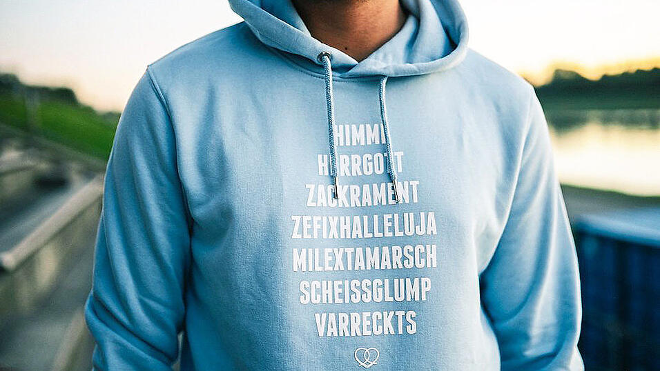 Bairische Aufdrücke wie'Wer nia furt kummt, kummt a nia hoam.' (orangefarbener Pulli)machen 'Bavarian Couture' aus.Fotos: Bavarian Couture Bairische Aufdrücke wie'Wer nia furt kummt, kummt a nia hoam.' (orangefarbener Pulli)machen 'Bavarian Couture' aus.Fotos: Bavarian Couture