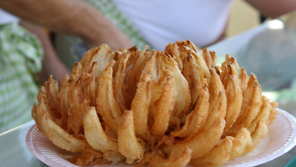 So sieht eine fertige Zwiebelrose im Bierteig aus. Sie schmeckt wie eine geröstete Zwiebel im Teigmantel. Serviert wird sie mit verschiedenen Soßen. So sieht eine fertige Zwiebelrose im Bierteig aus. Sie schmeckt wie eine geröstete Zwiebel im Teigmantel. Serviert wird sie mit verschiedenen Soßen.