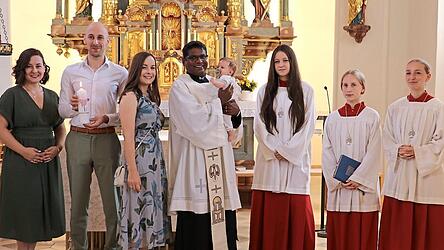 Nachdem der Priester die kleine Franziska getauft hatte, &uuml;bergab er symbolisch den Eltern das Licht Christi.