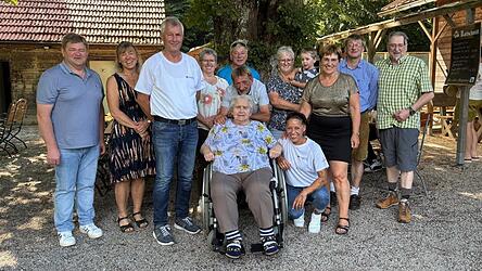 Die Rot-Kreuz-Mitarbeiter Mona Wei&szlig; (vorne, in der Hocke) und Rudi Stelzl (3.v.l.) wurden am Samstag herzlich im Kreis der Familie von Agnes Tremmel (im Rollstuhl) aufgenommen. Als Dritte von rechts ist &bdquo;Geburtstagskind&ldquo; Theresia Kirschner zu sehen, die sich mit ihrem Herzenswunsch an den BRK-Kreisverband gewandt hatte. Die Aufnahme zeigt sie mit ihren acht Geschwistern und einem Urenkelchen ihrer Mutter.