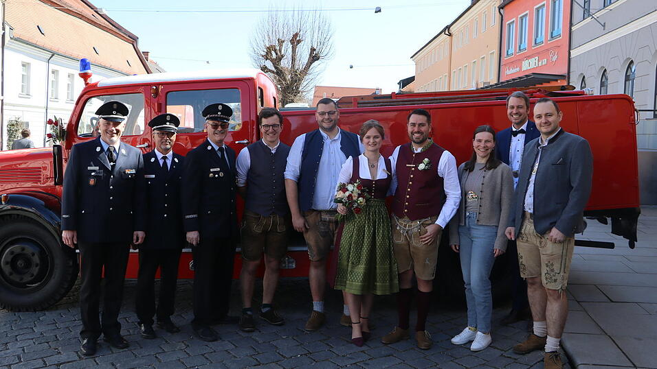 Das Brautpaar mit Gästen vor dem Rathaus.