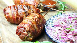 Finger-Food mal anders: Diese Hackfleischspieße sind mit Käse gefüllt und mit Speck ummantelt.