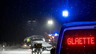 Auf der verschneiten Bundesstra&szlig;e 12 warnt an einer Unfallstelle ein Polizeifahrzeug vor Gl&auml;tte.