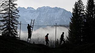 Arbeiter bauen im Wald rund um Schloss Elmau den Sperrzaun f&uuml;r den G7-Gipfel auf.