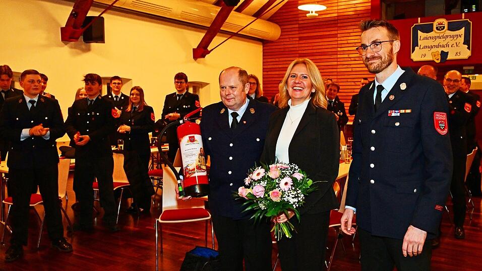 Die &uuml;berraschte B&uuml;rgermeisterin Susanne Hoyer nimmt umringt von F&ouml;rderverein-Vorsitzendem Thomas Glier und Kommandant Thomas Schmidt (r.) den Applaus entgegen: Sie wurde zum Ehrenmitglied ernannt.