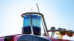 Auf dem Dach eines Einsatzfahrzeugs der Feuerwehr ist ein Blaulicht zu sehen.