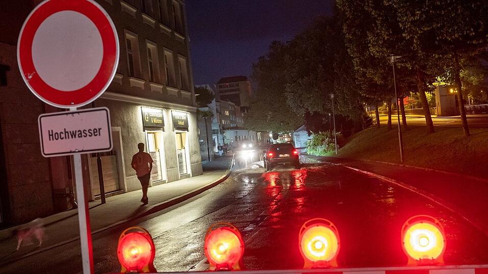 Eine Absperrschild mit der Aufschrift 'Hochwasser' steht am Abend an einer Straße in Passau nahe der Donau. Eine Absperrschild mit der Aufschrift 'Hochwasser' steht am Abend an einer Straße in Passau nahe der Donau.