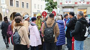 Das Modell der Stadt Landshut am Ländtor wird von den Kreuzfahrt-Touristen dicht umlagert. Unübersehbar sind die knallroten Täfelchen der Begleiterinnen. Schließlich soll kein Mitglied der Gruppe verloren gehen.