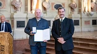 Für seinen Einsatz erhält Markus Hofmann (links) aus den Händen des Ministerpräsidenten die Christophorus-Medaille.