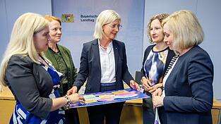 Die Kommissionsmitglieder Melanie Huml (CSU, l.), Mia Goller (Grüne, 2. v. l.), Marina Jakob (Freie Wähler, 2. v. r.) und Doris Rauscher (SPD, r.) übergeben ihre Empfehlungen an Familienministerin Ulrike Scharf. Die Kommissionsmitglieder Melanie Huml (CSU, l.), Mia Goller (Grüne, 2. v. l.), Marina Jakob (Freie Wähler, 2. v. r.) und Doris Rauscher (SPD, r.) übergeben ihre Empfehlungen an Familienministerin Ulrike Scharf.