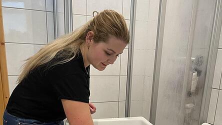 Mit dem Unterarm schätzt die Hebamme die Temperatur des Badewassers. 