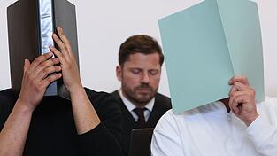Der Hauptangeklagte (r) sitzt in einem Gerichtssaal neben weiteren Angeklagten vor Rechtsanwalt Harald Stehr (M) auf der Anklagebank. Der Mann wurde wegen eines Böllerwurfs mit zwölf Verletzten zu einer Gefängnisstrafe verurteilt, das Urteil ist nun rechtskräftig. (Archivbild)
