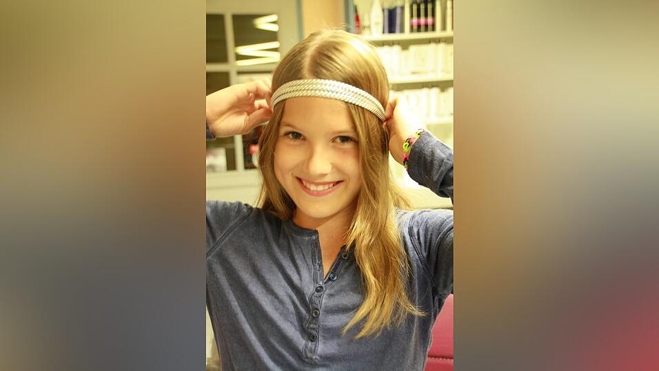 1. Lea nimmt ein gut sitzendes Haarband (nicht zu streng) und schiebt es &uuml;ber Kopf und Stirn.