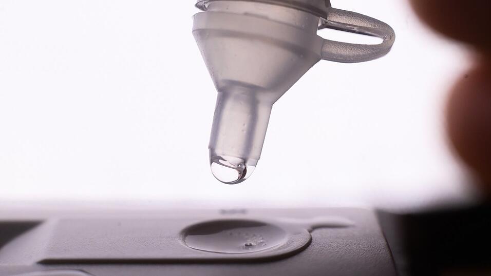 Fl&uuml;ssigkeit wird auf einen Corona-Selbsttest getr&ouml;pfelt.