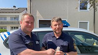 Zwei Polizisten mit einem Schwanenküken. Zwei Polizisten mit einem Schwanenküken.