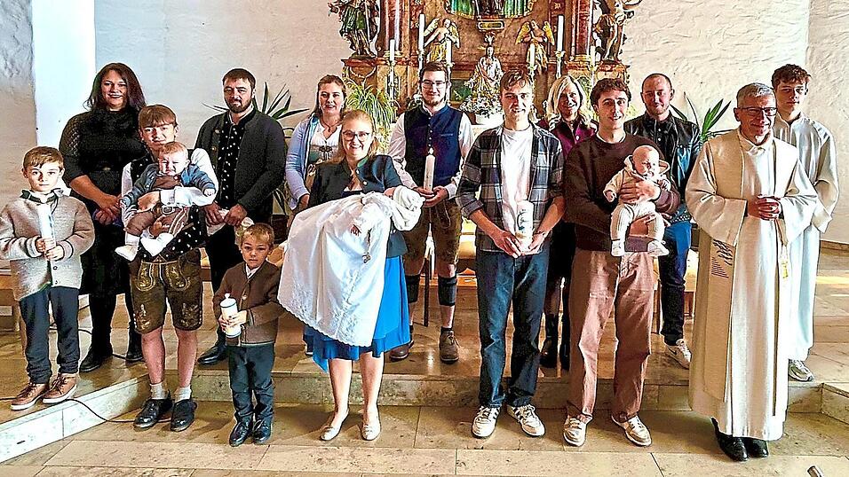 Josef, Korbinian und Georg auf dem Arm ihres jeweiligen Paten mit ihren Eltern, Pfarrer Johann Wutz, Ministrant Silas Schmid sowie Josefs &bdquo;gro&szlig;en&ldquo; Br&uuml;dern Martin und Tobias.